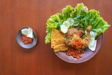 Ayam penyet, Endonezya 'da kızarmış tavuk çeşididir ve tavuk, salatalık dilimi, kızarmış tempo, marul, sambal ve biber ile servis edilir.