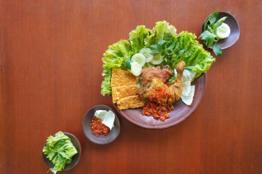 Ayam penyet, Endonezya 'da kızarmış tavuk çeşididir ve tavuk, salatalık dilimi, kızarmış tempo, marul, sambal ve biber ile servis edilir.
