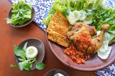 Ayam penyet, Endonezya 'da kızarmış tavuk çeşididir ve tavuk, salatalık dilimi, kızarmış tempo, marul, sambal ve biber ile servis edilir.