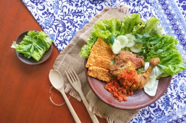 Ayam penyet, Endonezya 'da kızarmış tavuk çeşididir ve tavuk, salatalık dilimi, kızarmış tempo, marul, sambal ve biber ile servis edilir.