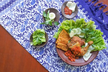Ayam penyet, Endonezya 'da kızarmış tavuk çeşididir ve tavuk, salatalık dilimi, kızarmış tempo, marul, sambal ve biber ile servis edilir.