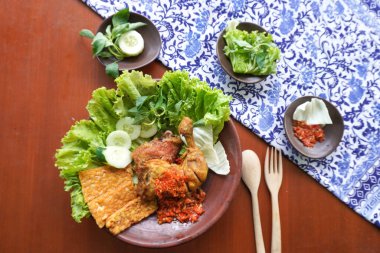 Ayam penyet, Endonezya 'da kızarmış tavuk çeşididir ve tavuk, salatalık dilimi, kızarmış tempo, marul, sambal ve biber ile servis edilir.