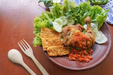 Ayam penyet, Endonezya 'da kızarmış tavuk çeşididir ve tavuk, salatalık dilimi, kızarmış tempo, marul, sambal ve biber ile servis edilir.