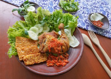 Ayam penyet, Endonezya 'da kızarmış tavuk çeşididir ve tavuk, salatalık dilimi, kızarmış tempo, marul, sambal ve biber ile servis edilir.