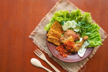 Ayam penyet, Endonezya 'da kızarmış tavuk çeşididir ve tavuk, salatalık dilimi, kızarmış tempo, marul, sambal ve biber ile servis edilir.