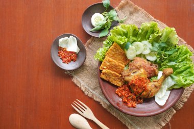 Ayam penyet, Endonezya 'da kızarmış tavuk çeşididir ve tavuk, salatalık dilimi, kızarmış tempo, marul, sambal ve biber ile servis edilir.