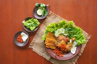 Ayam penyet, Endonezya 'da kızarmış tavuk çeşididir ve tavuk, salatalık dilimi, kızarmış tempo, marul, sambal ve biber ile servis edilir.