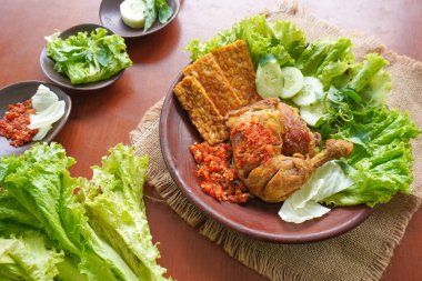 Ayam penyet, Endonezya 'da kızarmış tavuk çeşididir ve tavuk, salatalık dilimi, kızarmış tempo, marul, sambal ve biber ile servis edilir.