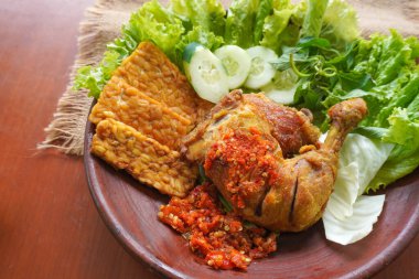 Ayam penyet, Endonezya 'da kızarmış tavuk çeşididir ve tavuk, salatalık dilimi, kızarmış tempo, marul, sambal ve biber ile servis edilir.