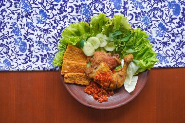 Ayam penyet, Endonezya 'da kızarmış tavuk çeşididir ve tavuk, salatalık dilimi, kızarmış tempo, marul, sambal ve biber ile servis edilir.