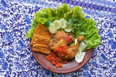 Ayam penyet, Endonezya 'da kızarmış tavuk çeşididir ve tavuk, salatalık dilimi, kızarmış tempo, marul, sambal ve biber ile servis edilir.