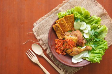 Ayam penyet, Endonezya 'da kızarmış tavuk çeşididir ve tavuk, salatalık dilimi, kızarmış tempo, marul, sambal ve biber ile servis edilir.