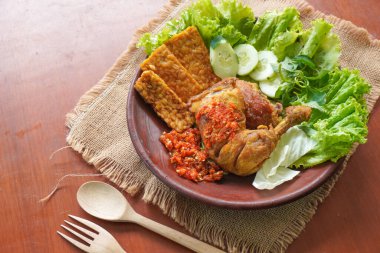 Ayam penyet, Endonezya 'da kızarmış tavuk çeşididir ve tavuk, salatalık dilimi, kızarmış tempo, marul, sambal ve biber ile servis edilir.