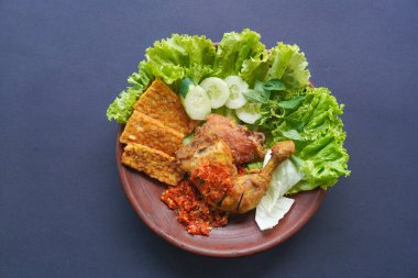 Ayam penyet, Endonezya 'da kızarmış tavuk çeşididir ve tavuk, salatalık dilimi, kızarmış tempo, marul, sambal ve biber ile servis edilir.