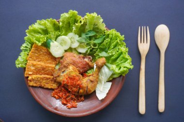 Ayam penyet, Endonezya 'da kızarmış tavuk çeşididir ve tavuk, salatalık dilimi, kızarmış tempo, marul, sambal ve biber ile servis edilir.