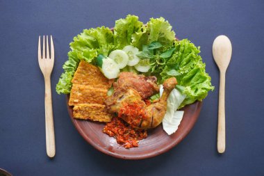 Ayam penyet, Endonezya 'da kızarmış tavuk çeşididir ve tavuk, salatalık dilimi, kızarmış tempo, marul, sambal ve biber ile servis edilir.