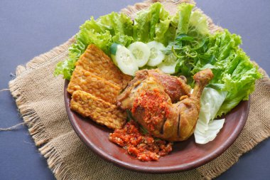 Ayam penyet, Endonezya 'da kızarmış tavuk çeşididir ve tavuk, salatalık dilimi, kızarmış tempo, marul, sambal ve biber ile servis edilir.