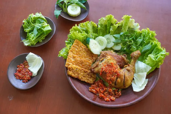 Ayam penyet, Endonezya 'da kızarmış tavuk çeşididir ve tavuk, salatalık dilimi, kızarmış tempo, marul, sambal ve biber ile servis edilir.