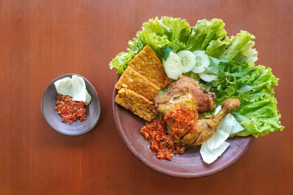 Ayam penyet, Endonezya 'da kızarmış tavuk çeşididir ve tavuk, salatalık dilimi, kızarmış tempo, marul, sambal ve biber ile servis edilir.