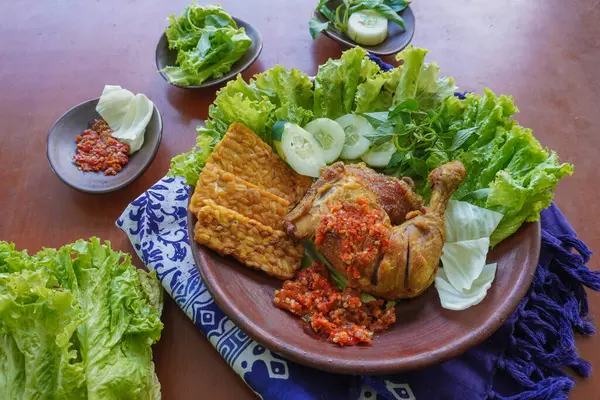 Ayam penyet, Endonezya 'da kızarmış tavuk çeşididir ve tavuk, salatalık dilimi, kızarmış tempo, marul, sambal ve biber ile servis edilir.