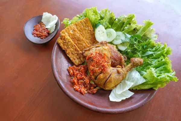 Ayam penyet, Endonezya 'da kızarmış tavuk çeşididir ve tavuk, salatalık dilimi, kızarmış tempo, marul, sambal ve biber ile servis edilir.