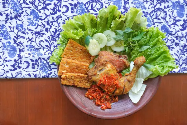 Ayam penyet, Endonezya 'da kızarmış tavuk çeşididir ve tavuk, salatalık dilimi, kızarmış tempo, marul, sambal ve biber ile servis edilir.