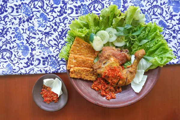 Ayam penyet, Endonezya 'da kızarmış tavuk çeşididir ve tavuk, salatalık dilimi, kızarmış tempo, marul, sambal ve biber ile servis edilir.