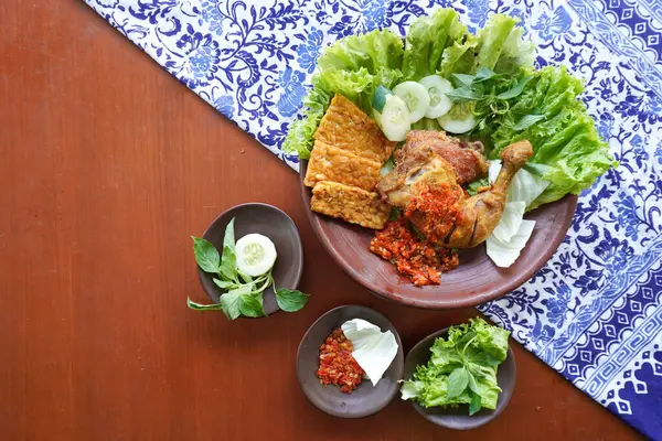 Ayam penyet, Endonezya 'da kızarmış tavuk çeşididir ve tavuk, salatalık dilimi, kızarmış tempo, marul, sambal ve biber ile servis edilir.