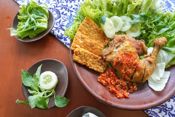 Ayam penyet, Endonezya 'da kızarmış tavuk çeşididir ve tavuk, salatalık dilimi, kızarmış tempo, marul, sambal ve biber ile servis edilir.