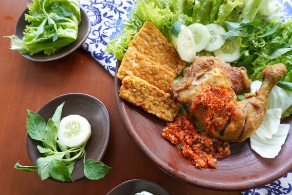 Ayam penyet, Endonezya 'da kızarmış tavuk çeşididir ve tavuk, salatalık dilimi, kızarmış tempo, marul, sambal ve biber ile servis edilir.