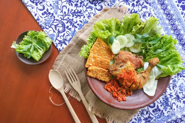 Ayam penyet, Endonezya 'da kızarmış tavuk çeşididir ve tavuk, salatalık dilimi, kızarmış tempo, marul, sambal ve biber ile servis edilir.