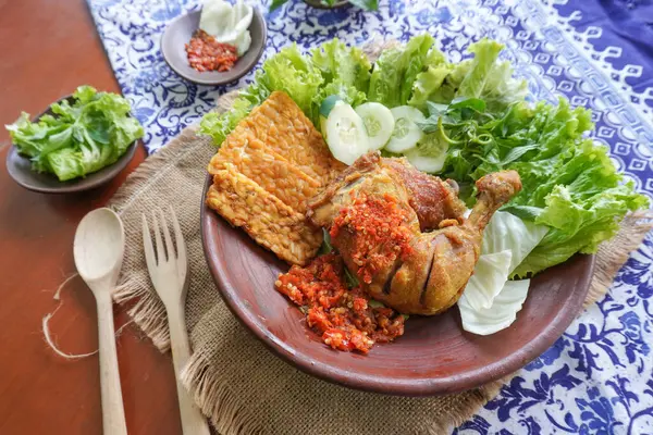 Ayam penyet, Endonezya 'da kızarmış tavuk çeşididir ve tavuk, salatalık dilimi, kızarmış tempo, marul, sambal ve biber ile servis edilir.