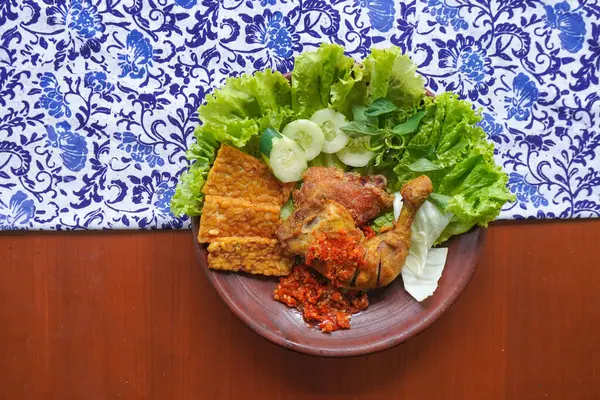 Ayam penyet, Endonezya 'da kızarmış tavuk çeşididir ve tavuk, salatalık dilimi, kızarmış tempo, marul, sambal ve biber ile servis edilir.