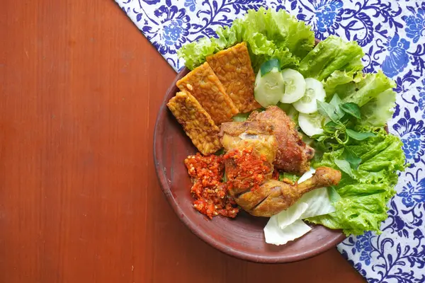 Ayam penyet, Endonezya 'da kızarmış tavuk çeşididir ve tavuk, salatalık dilimi, kızarmış tempo, marul, sambal ve biber ile servis edilir.