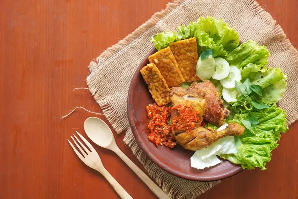 Ayam penyet, Endonezya 'da kızarmış tavuk çeşididir ve tavuk, salatalık dilimi, kızarmış tempo, marul, sambal ve biber ile servis edilir.