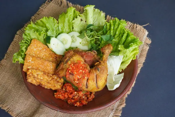 Ayam penyet, Endonezya 'da kızarmış tavuk çeşididir ve tavuk, salatalık dilimi, kızarmış tempo, marul, sambal ve biber ile servis edilir.