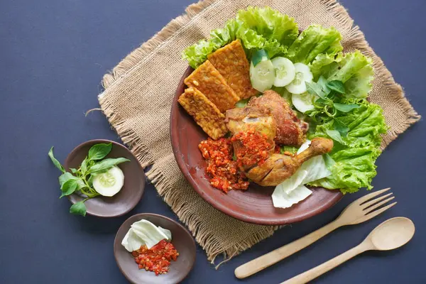 Ayam penyet, Endonezya 'da kızarmış tavuk çeşididir ve tavuk, salatalık dilimi, kızarmış tempo, marul, sambal ve biber ile servis edilir.