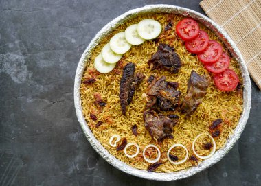 Geleneksel kebuli pilavı, aromatik baharatlı pirinç yemeği, taze et, kuru üzüm, salatalık, soğan, baharat ve taze domates dilimleri ile servis edilir.