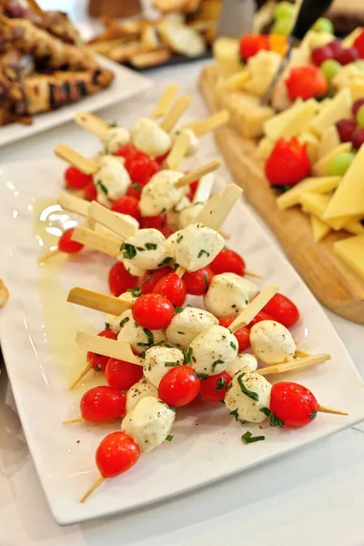 Kiraz domatesleri, bocconcini, fesleğen ve balzamik redüksiyondan yapılmış Caprese salata şişlerinin yüksek açılı görüntüsü
