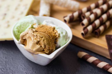 Waffle dürümleri. Çikolatalı waffle, çikolatalı dondurma ve siyah arka planda dondurma.