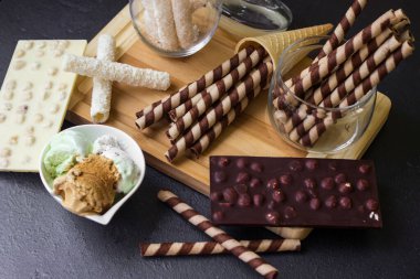 Waffle dürümleri. Çikolatalı waffle, çikolatalı dondurma ve siyah arka planda dondurma.