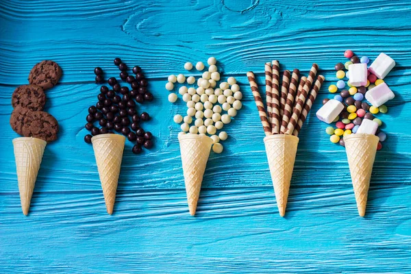 Ice cream cones with colorful candies, cookies, and chocolate balls