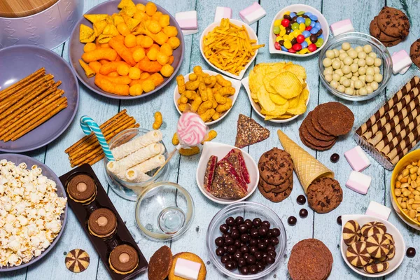 stock image Table of salty and sweet snacks. Large group of unhealthy food