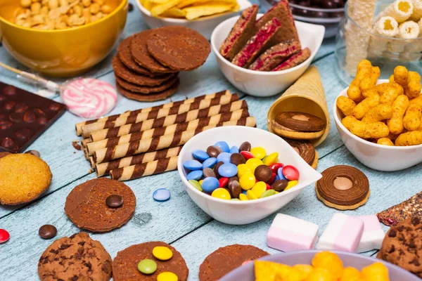 stock image Table of salty and sweet snacks. Large group of unhealthy food