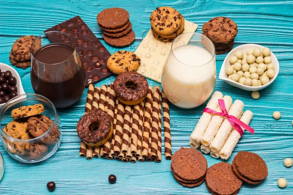 Шоколадное Печенье Банке Куча Сладостей Стаканами Молока Синем Фоне — стоковое фото