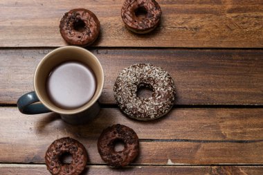 Çeşitli çikolatalı çörekler ve tahta arka planda çikolatalı süt.