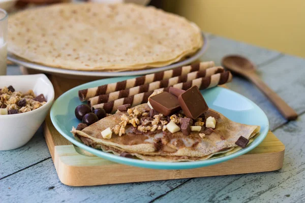 Crepes with chocolate on cutting board with ingredients