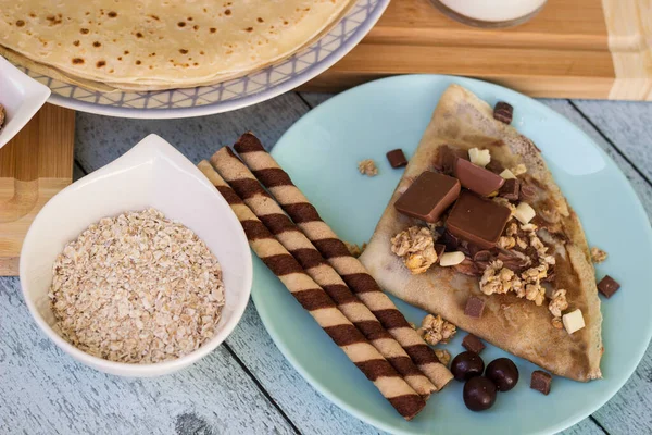 Crepes with chocolate on cutting board with ingredients