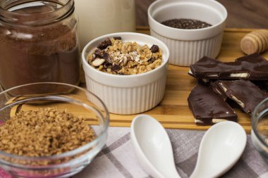Bir kase çikolatalı granola, sütlü ve diğer malzemeli.