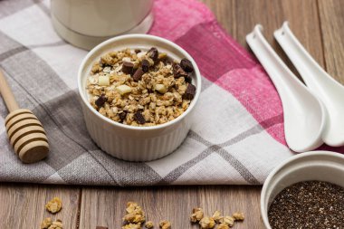 Bir kase çikolatalı granola, sütlü ve diğer malzemeli.